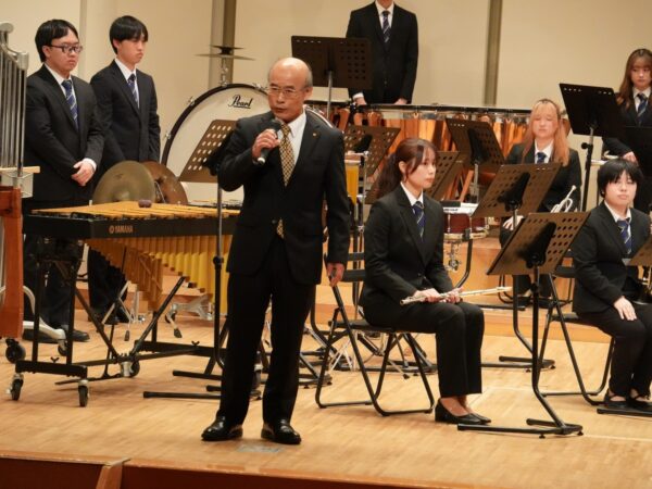 ステージ上で挨拶する岡戸理事長